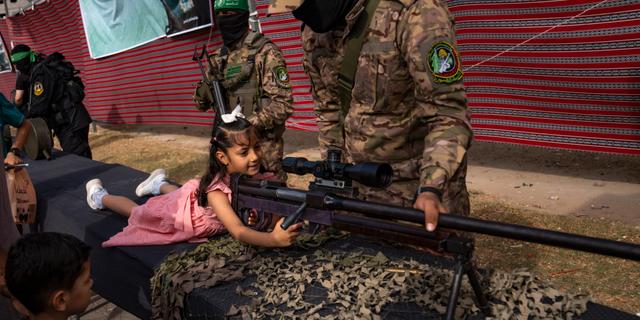 Palestinsk flicka poserar med ett vapen. Fatima Shbair / AP