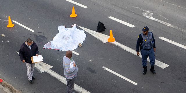 Ett övertäckt lik efter de våldsamma taxiprotesterna i Sydafrika. AP