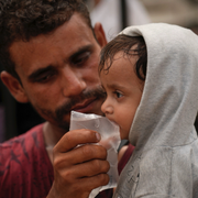 Ett barn får vatten i Gaza stad. 